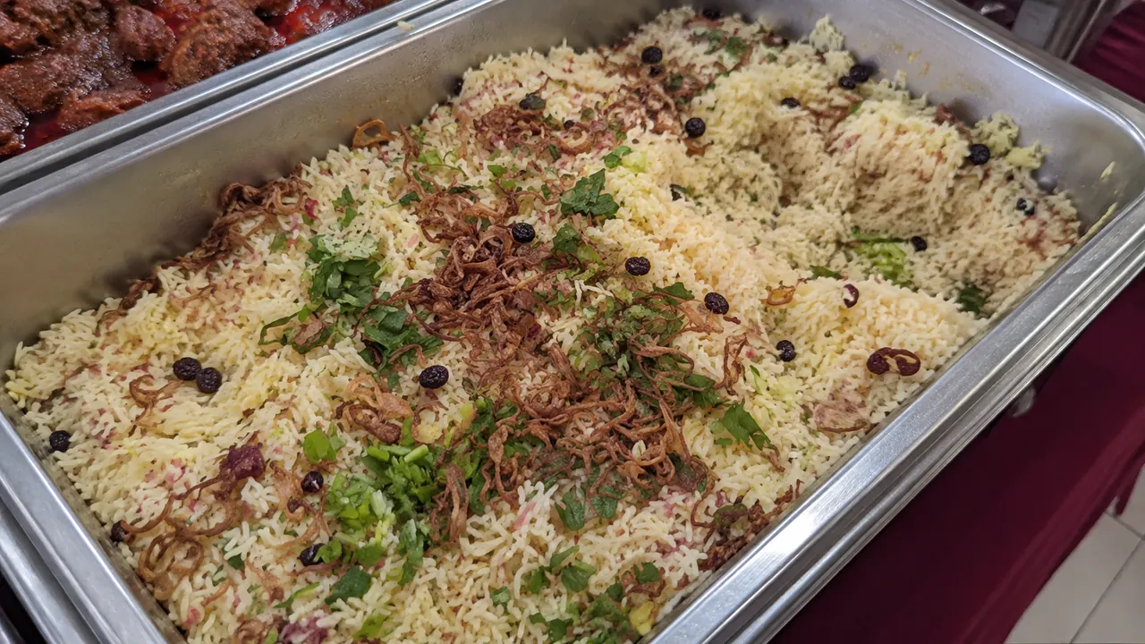 Nasi briyani dengan bawang goreng dalam dulang besi