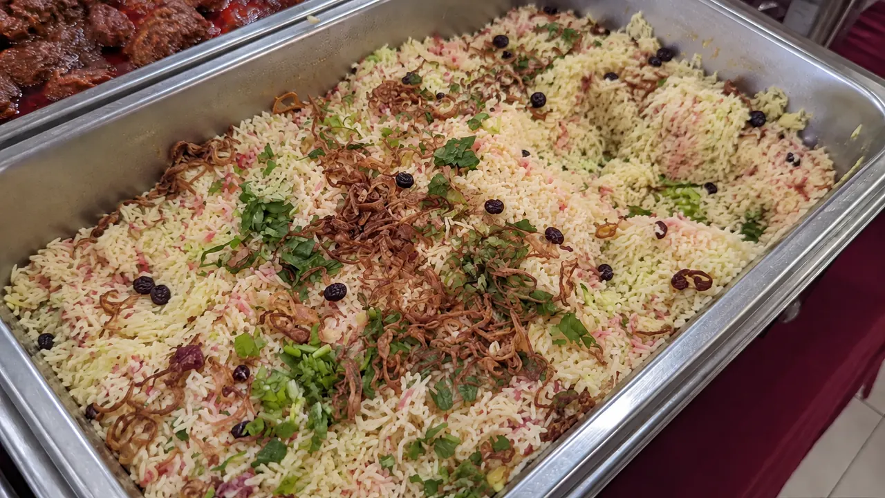 Nasi minyak berwarna hijau dan merah dalam dulang besi